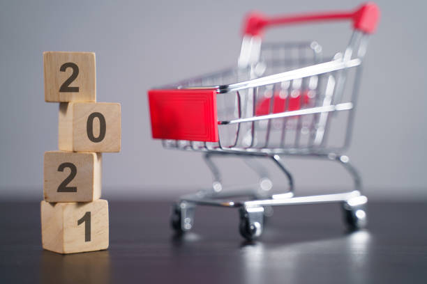 istock Text 2021 on wooden cube with shopping cart. 1294087892