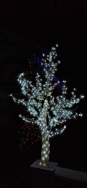 istock White LED fairy light tree with lighted up small flowers on its branches at night. 1294090916