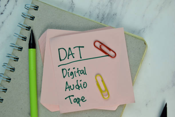 istock DAT - Digital Audio Tape write on sticky note isolated on Wooden Table. 1294093935