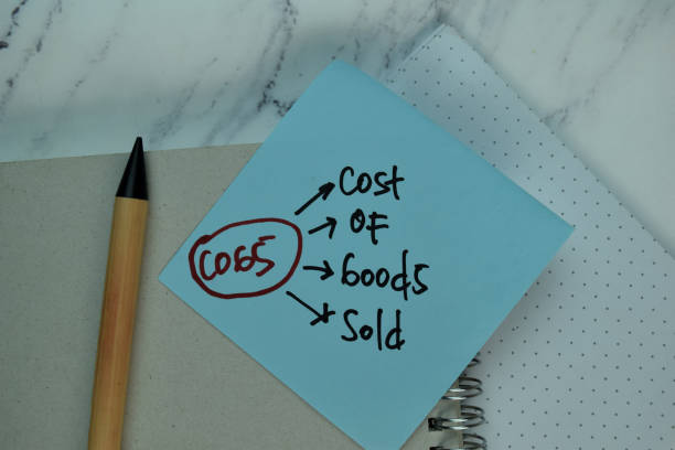 istock COGS - Cost Of Goods Sold write on sticky note isolated on Wooden Table. 1294093964