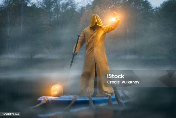 Man On A Paddle Board In A Yellow Raincoat Photo Art Charon And The River Styx Stock Photo - Download Image Now