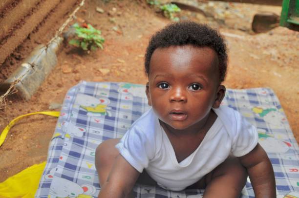 istock Cute Baby Is Sitting On A Blanket On The Floor 1294101982