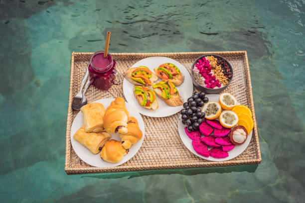 istock Breakfast tray in swimming pool, floating breakfast in luxury hotel smoothies and fruit plate, smoothie bowl by the hotel pool. Exotic summer diet. Tropical beach lifestyle. Bali Trend 1294103099