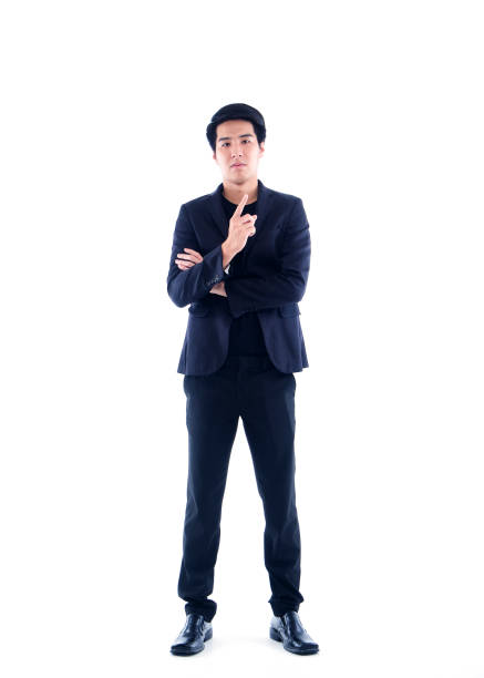 istock Handsome man in black suit pointing on white background 1294105698