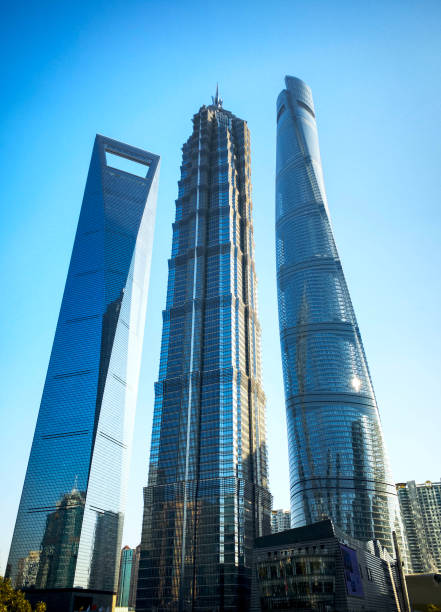 Shanghai Skyscrapers The three tallest buildings of Shanghai equidistant on one picture, as seen from below. Grey-ish blue, cloudless sky. No people. shanghai tower stock pictures, royalty-free photos & images