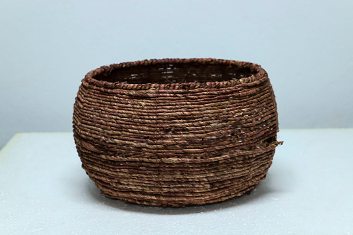 An old brown wicker basket isolated on white background, handicraft