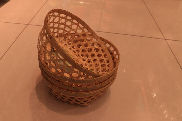 istock Four handmade bamboo woven draining baskets stacked on the indoor floor. 1294110551