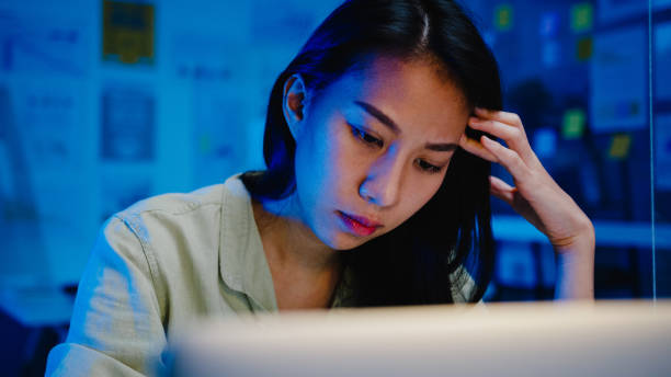 istock Freelance Asia women using laptop hard work at new normal office. Working from home overload at night. 1294110895