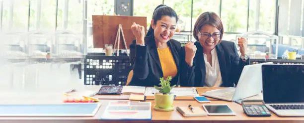 Photo of Banner Happy success business woman partner meeting working together in company office. Panoramic picture of Meeting Executive Asian business woman office desk with fist arm raised executive teamwork