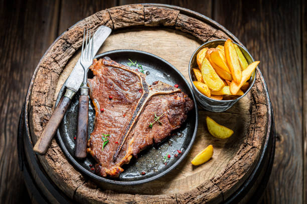 istock Tasty chips and well done tbone steak on old barrel 1294115936