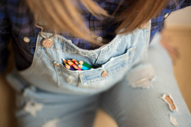 smiling young woman lying on the floor and drawing with colored markers