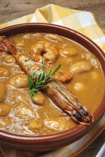 Homemade White Bean Stew with Prawns Traditional Homemade White Bean Stew with Prawns. Typical Spanish food. on wooden background fabes stock pictures, royalty-free photos & images