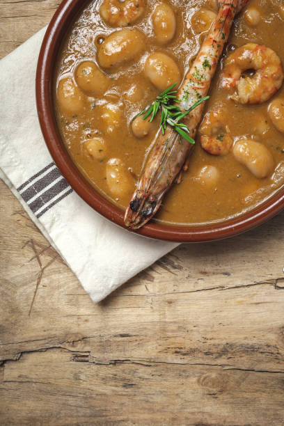 Homemade White Bean Stew with Prawns Traditional Homemade White Bean Stew with Prawns. Typical Spanish food. on wooden background fabes stock pictures, royalty-free photos & images