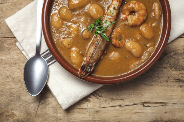 Homemade White Bean Stew with Prawns Traditional Homemade White Bean Stew with Prawns. Typical Spanish food. on wooden background fabes stock pictures, royalty-free photos & images