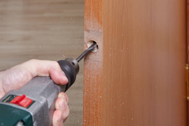 istock The locksmith uses a flat spade bit  for wood  to drill a handle hole with a lock in an interior wooden door. 1294120683