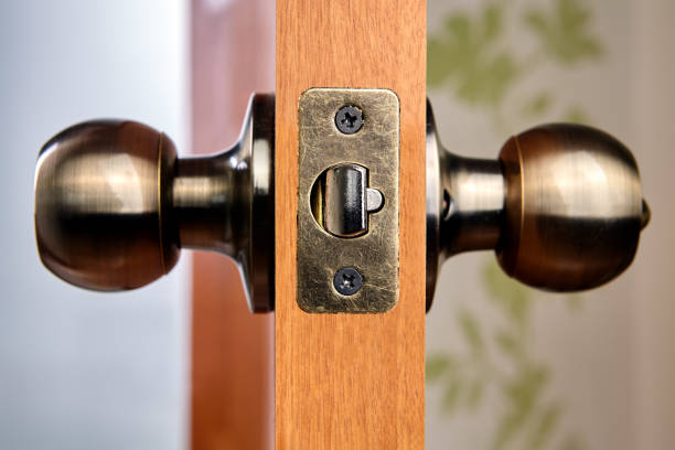 Close-up of new brass door handles with latch. New wooden interior door complete with a handle and latch made of brass. door chain stock pictures, royalty-free photos & images