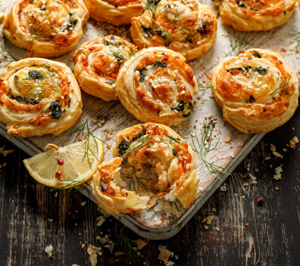 istock Puff Pastry Pinwheels stuffed with salmon, cheese and spinach served on a board on a black wooden table 1294123722