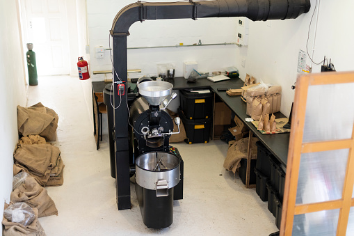High angle view coffee roasting machine in back room of cafe