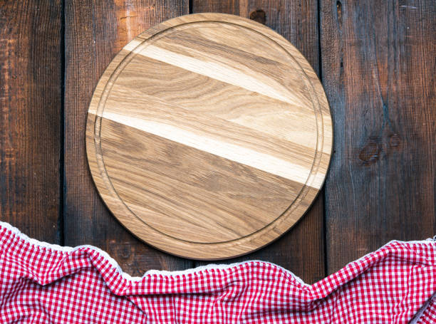 istock empty round wooden cutting board and red napkin 1294125549