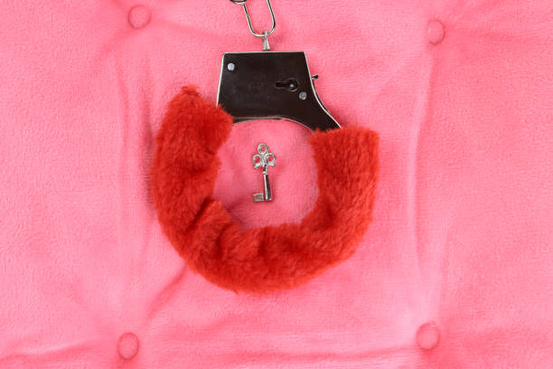 istock pink fluffy handcuffs on the pillow. Valentine's Day 1294126445