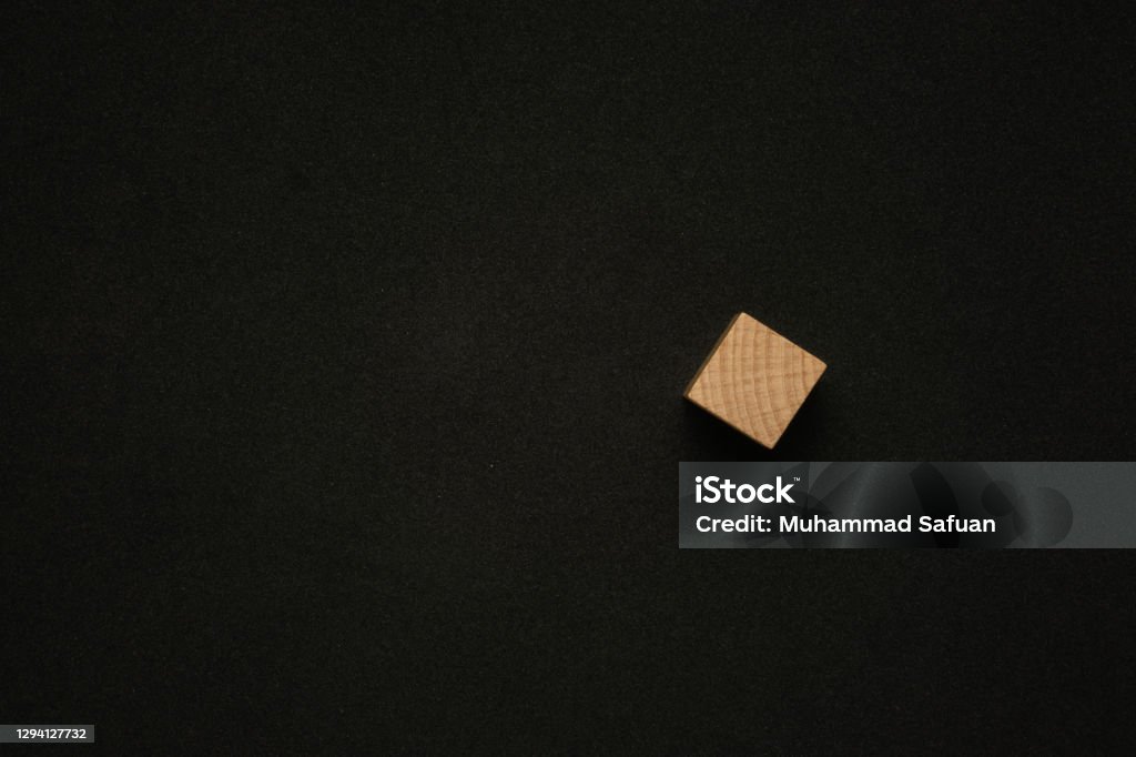 Single wooden cube on black background with a copy space. Flat lay view concept. Text Stock Photo