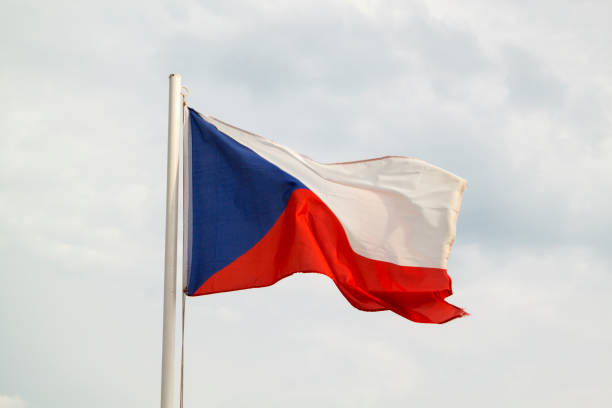 istock Czech Republic flag on a blue sky with clouds background 1294129423