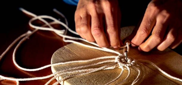 istock First knots to make a macrame coaster from a rope on a plate of wood 1294129472