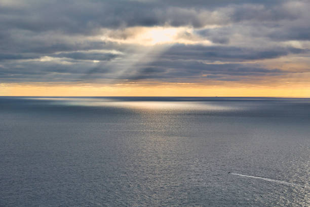 istock Sunset sky with clouds over ocean with raylights storm 1294130843