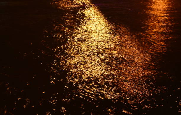 istock blurry of artificial light pole reflection on canal 1294132579