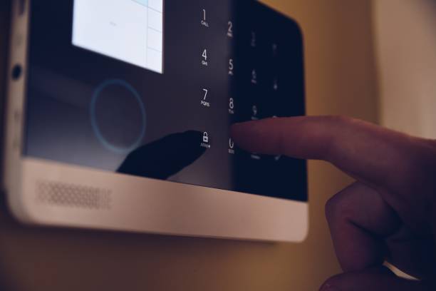 istock Man arming home security alarm. Home alarm system 1294133920