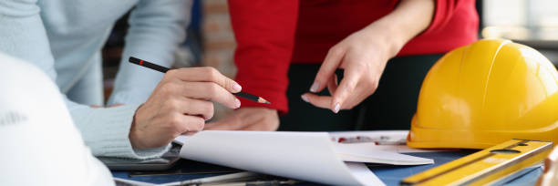 istock Two women looking at documents and showing them in pencil in design studio 1294134905