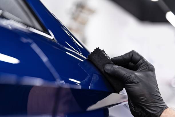 istock Car detailing studio worker applying ceramic coating on car 1294134948