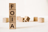 Word foia. Wooden small cubes with letters on white background with copy space available.