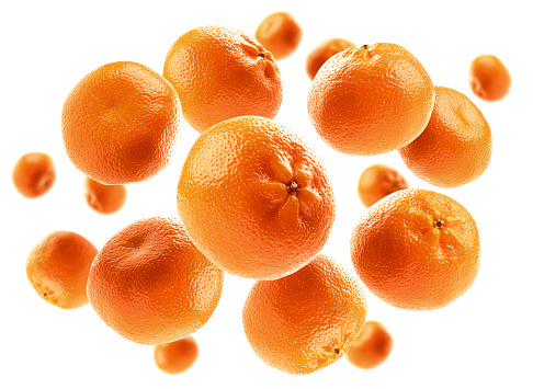 Whole oranges levitate on a white background.
