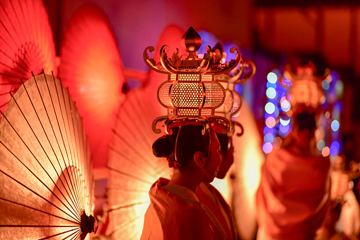 A beautiful festival with bamboo lanterns and Japanese umbrellas lit upIt is a winter light festival that was held on February 16, 2019 in Yamaga City, Kumamoto Prefecture, Japan, where Japanese umbrellas and bamboo lanterns were lit up at night.It is a beautiful sight of a woman decorating a Yamaga lantern in front of a Japanese umbrella lit up at night at the winter light festival held in Yamaga City, Kumamoto Prefecture on February 16, 2019.