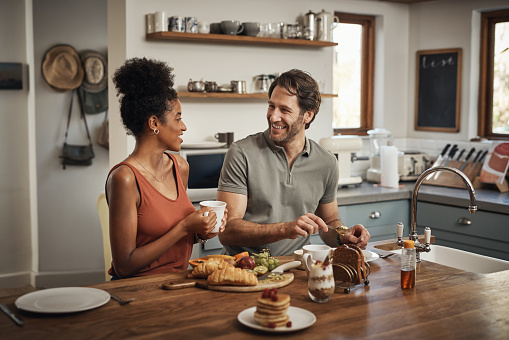 Cropped shot of an affectionate young couple having breakfast in their kitchen at home