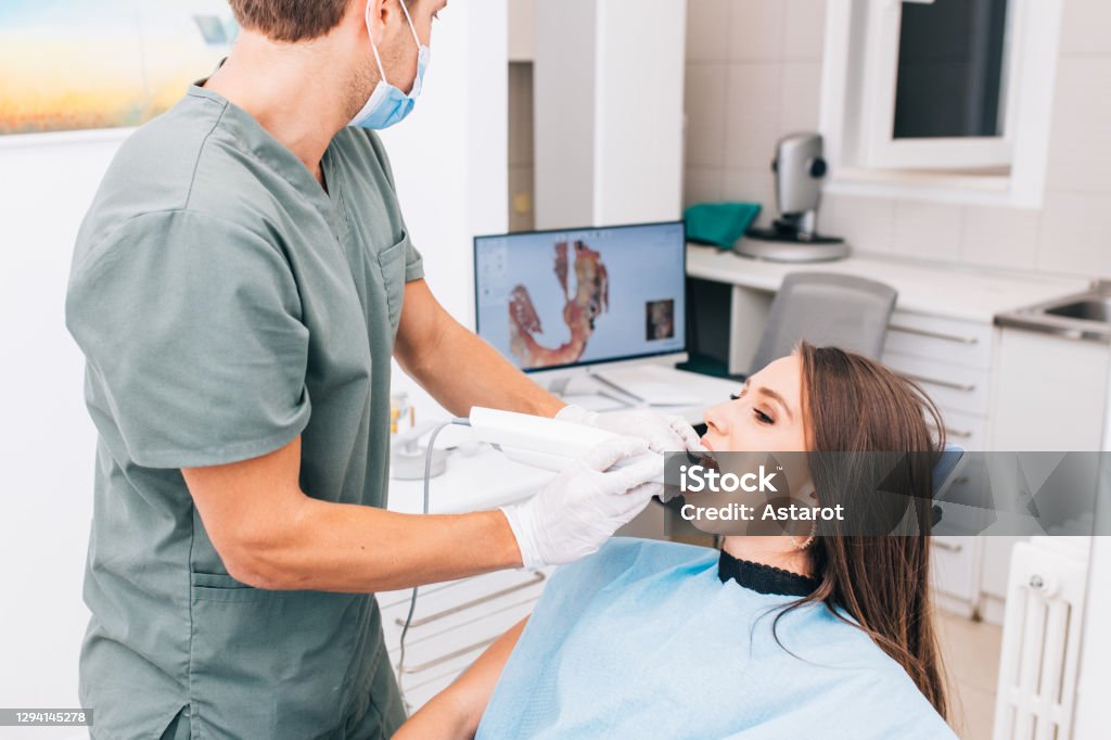 The dentist scans the patient's teeth with a 3d scanner. Dental Health Stock Photo