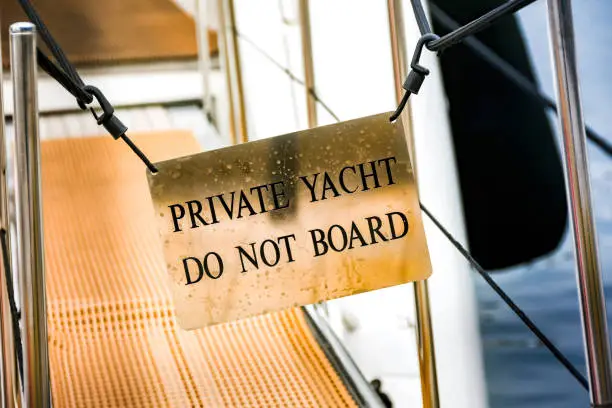 "Do not board" notice on the gangway of a luxury private yacht. No people.