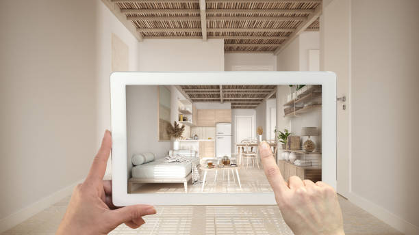 istock Augmented reality concept. Hand holding tablet with AR application used to simulate furniture and design products in empty interior with ceramic tiles. Kitchen, living room, sofa 1294147763