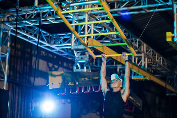 istock Asian Chinese man athlete competing in an obstacle course. Tilted monkey bar 1294147886
