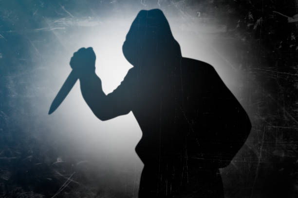 Murderer holding knife in his hand Shadow of the murderer holding the murder weapon. Silhouette of man with a knife in his hand kitchen knife photos stock pictures, royalty-free photos & images