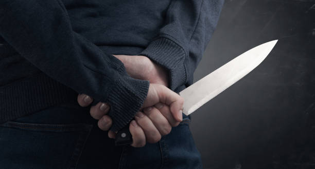 Murderer holding knife in his hand Close-up on the murderer holding the murder weapon. Man with a knife in his hand knife crime photos stock pictures, royalty-free photos & images