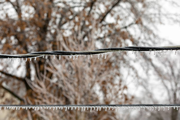Closeup of ice on power line from freezing rain. Concept of winter storm and power outage. background, no people utility pole with power lines close up stock pictures, royalty-free photos & images