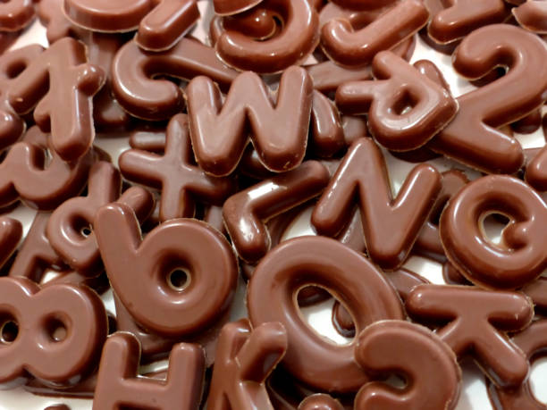 istock Pile of chocolate letters on white background 1294156905