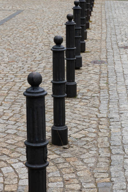 istock Black pillars on the sidewalk in the city. 1294159112
