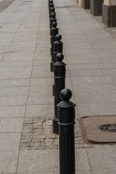 istock Black pillars on the sidewalk in the city. 1294159512