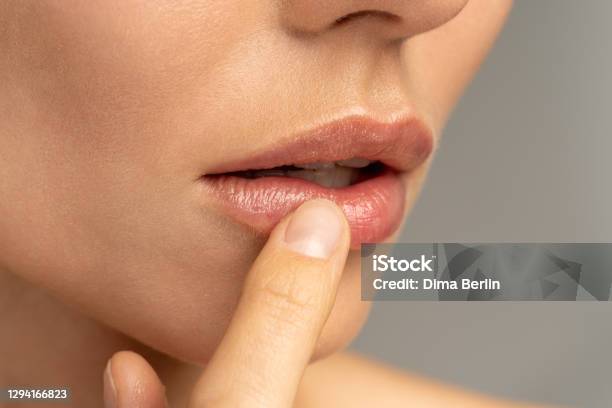 Close Up Of Woman Applying Moisturizing Nourishing Balm To Her Lips With Her Finger To Prevent Dryness And Chapping In The Cold Season Stock Photo - Download Image Now