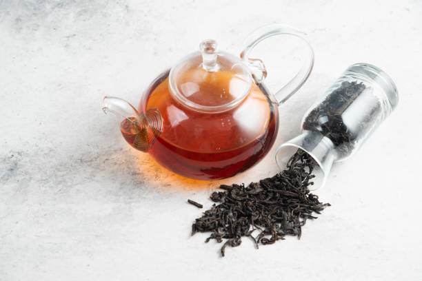 istock Dry tea leaves with teapot on a marble background 1294167749