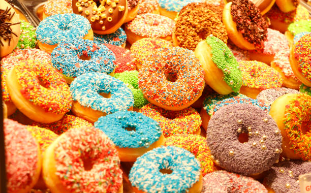 istock Closeup of colorful assorted donuts, ring-shaped desserts sold in bakery 1294169249