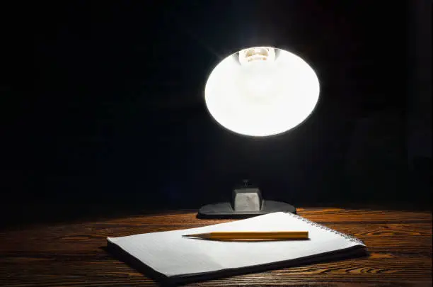 Notepad in the light of a table lamp